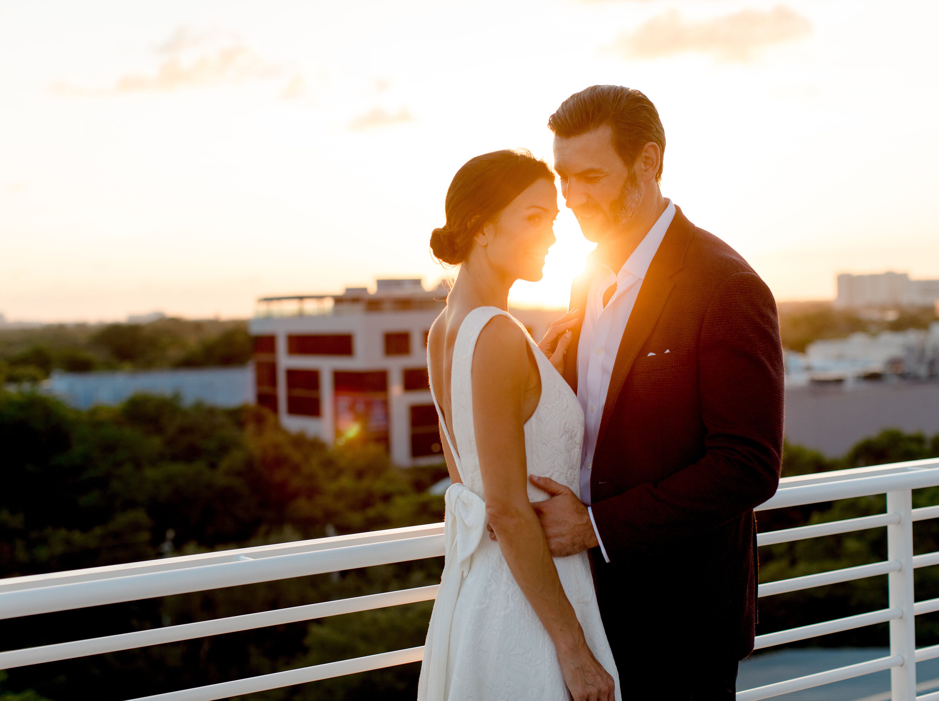external shot of bride and groom overlooking a sunset.